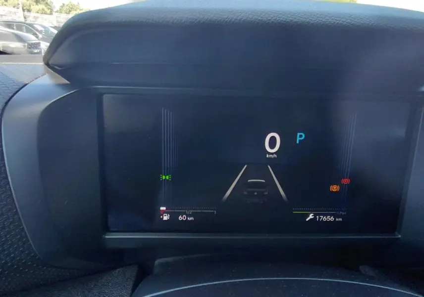 Vue rapprochée du tableau de bord numérique de la Citroën C4 X noire hybride 2025, affichant la vitesse et l'autonomie.