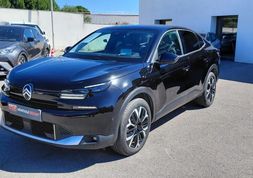 Citroën C4 X hybride noir vue 3/4 avant droit, avec jantes alliage 17 pouces et toit ouvrant panoramique.
