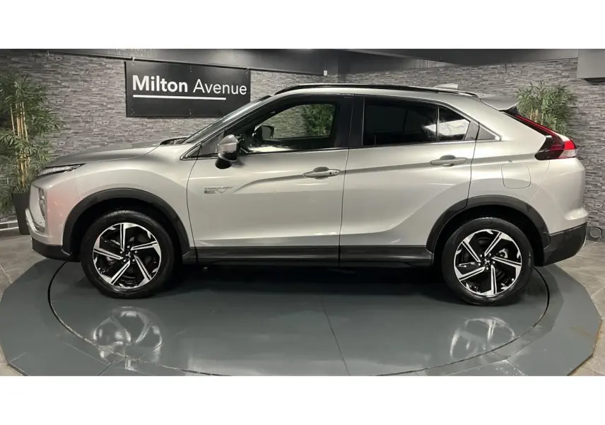 Vue de profil côté gauche d'un Mitsubishi Eclipse Cross gris métallisé avec jantes alliage bi-ton et toit noir.