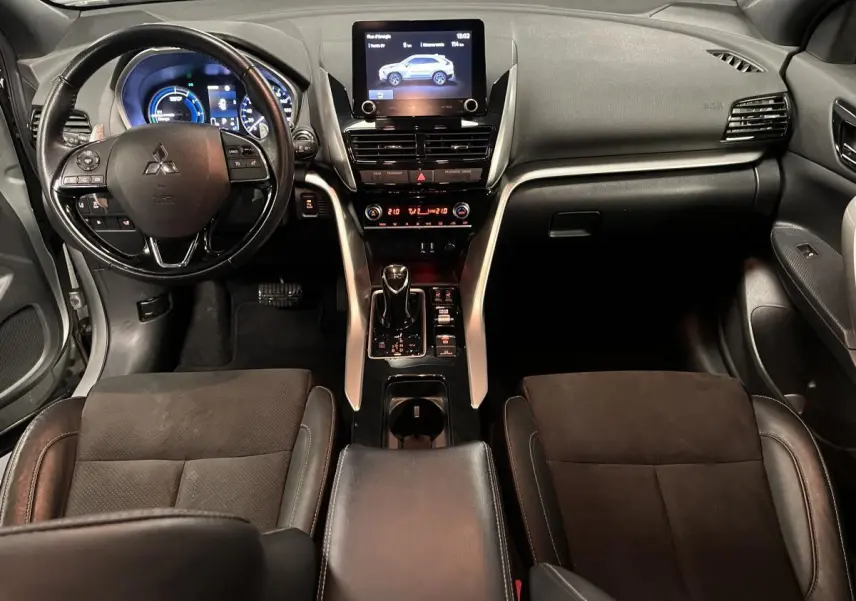 Vue intérieure avant du Mitsubishi Eclipse Cross gris, avec tableau de bord moderne et écran tactile central.