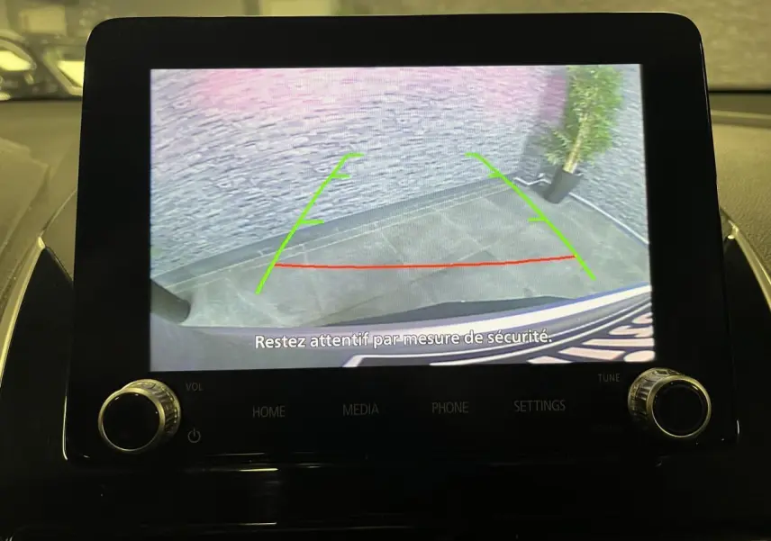 Écran multimédia montrant la caméra de recul du Mitsubishi Eclipse Cross 2022 avec lignes de guidage vertes et rouges.