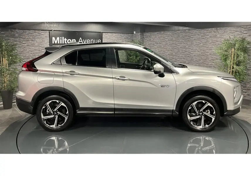 Profil côté gauche du Mitsubishi Eclipse Cross gris métallisé 2022 avec jantes alliage bi-ton et vitres surteintées.