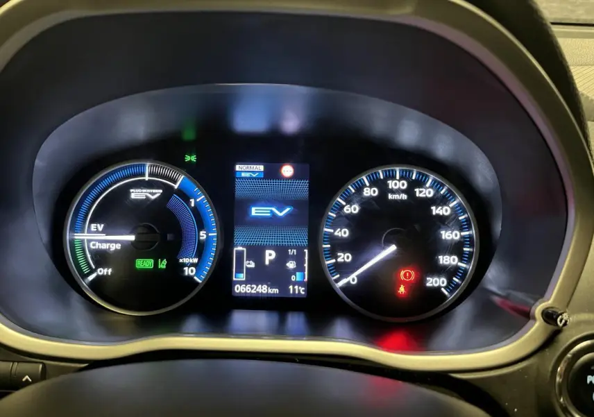 Tableau de bord du Mitsubishi Eclipse Cross hybride, affichage numérique EV et compteur analogique de vitesse jusqu'à 200 km/h.