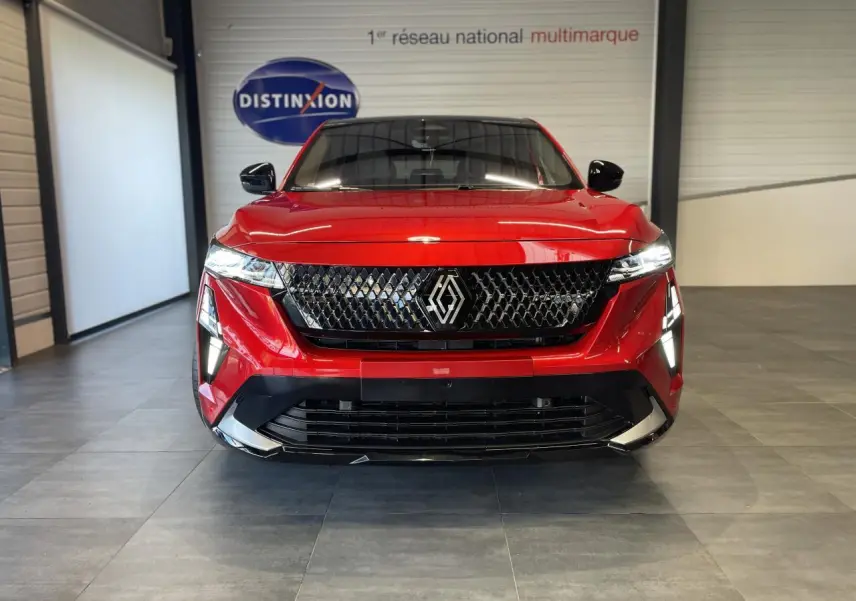Vue frontale d'un Renault Rafale 2025 rouge à toit noir avec calandre noire et feux LED distinctifs en intérieur showroom.