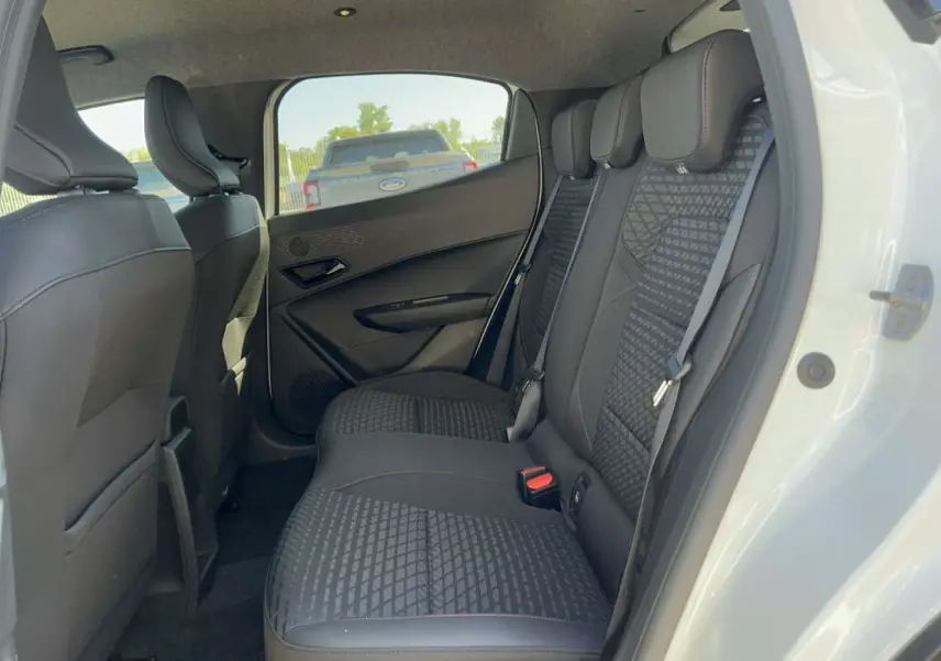 Vue intérieure côté droit sur la banquette arrière noire au tissu texturé d'une Renault Clio blanc glacier 2026.