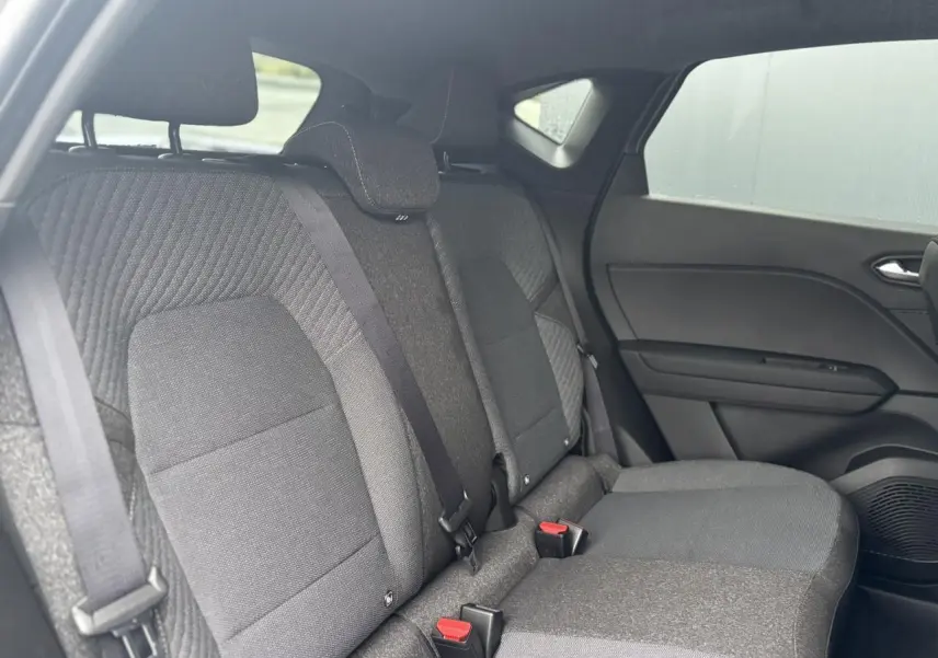 Vue intérieure arrière droite des sièges arrière gris foncé du Renault Captur 2025, avec ceinture de sécurité et appuie-tête.