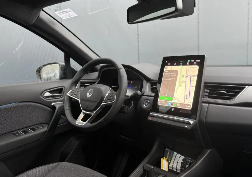 Vue intérieure côté conducteur du Renault Captur 2025, avec tableau de bord numérique et écran tactile vertical central.