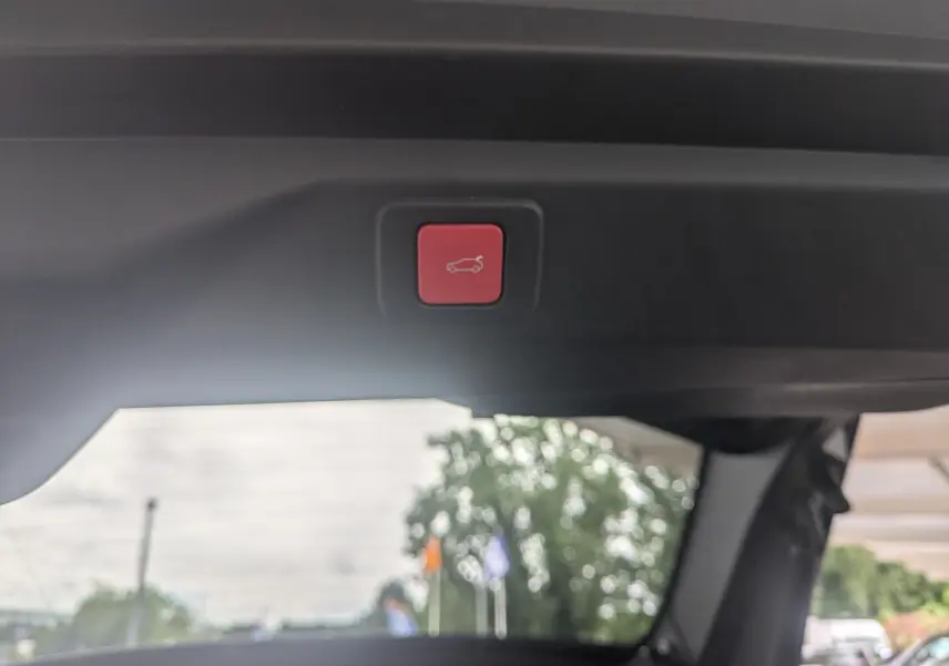 Bouton rouge de fermeture électrique du hayon vu de l'intérieur arrière du Peugeot 3008 Hybrid 145 GT Exclusive 2026.