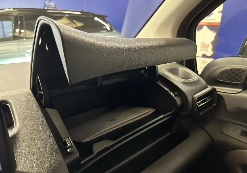 Gros plan sur la boîte à gants ouverte côté passager du Citroën Berlingo Multispace 2026, intérieur noir.
