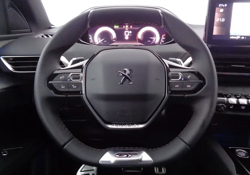 Vue rapprochée du volant cuir noir du Peugeot 3008 GT 2023 avec tableau de bord numérique et commandes intégrées.