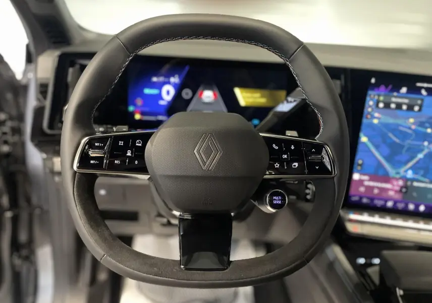 Vue rapprochée du volant multifonction en cuir et alcantara du Renault Austral 2025 avec tableau de bord numérique et écran tactile.