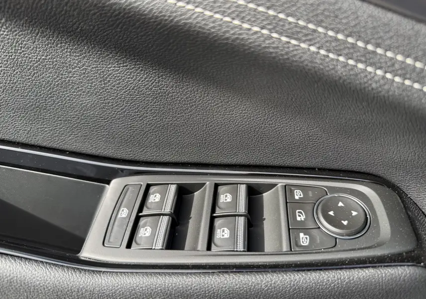 Détail des commandes intérieures noires du Renault Austral Full Hybrid, avec boutons de verrouillage et assistance au stationnement.