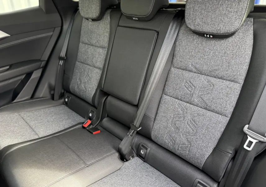 Vue intérieure des sièges arrière du Renault Austral noir étoile, avec sellerie tissu gris et détails en cuir noir.