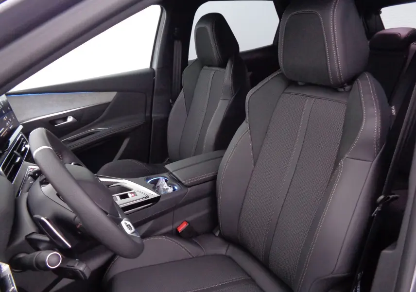 Vue intérieure côté conducteur du Peugeot 3008 2023, sièges en cuir noir avec surpiqûres contrastées.