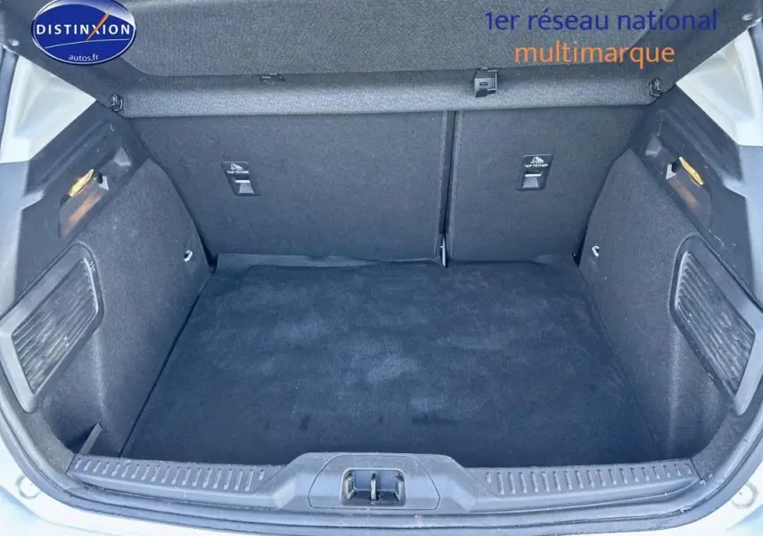 Coffre ouvert d'une Ford Focus gris clair 2019, vue arrière mettant en valeur l'espace de chargement propre et tapissé.