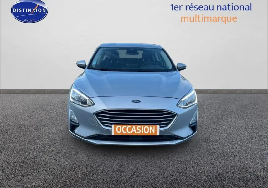 Vue frontale d'une Ford Focus gris clair 2019 avec calandre large et feux LED allumés sur fond neutre.