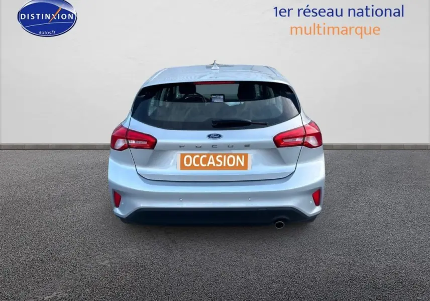 Vue arrière d'une Ford Focus gris clair 2019 avec feux rouges et plaque orange "OCCASION" sur fond neutre.