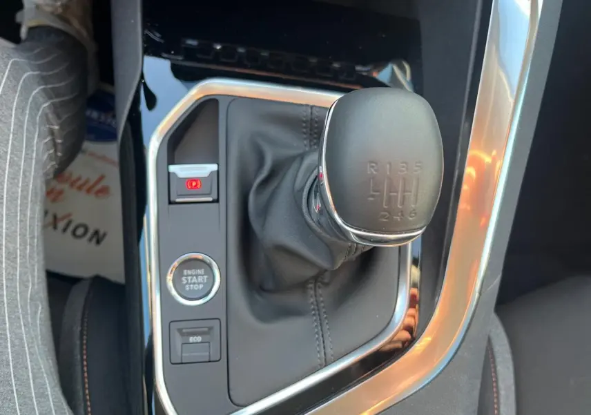 Gros plan sur le levier de vitesses manuel et les commandes centrales du Peugeot 3008 gris Artense 2023.