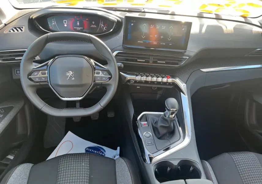 Vue intérieure du poste de conduite du Peugeot 3008 gris Artense 2023, avec volant compact et écran tactile central.