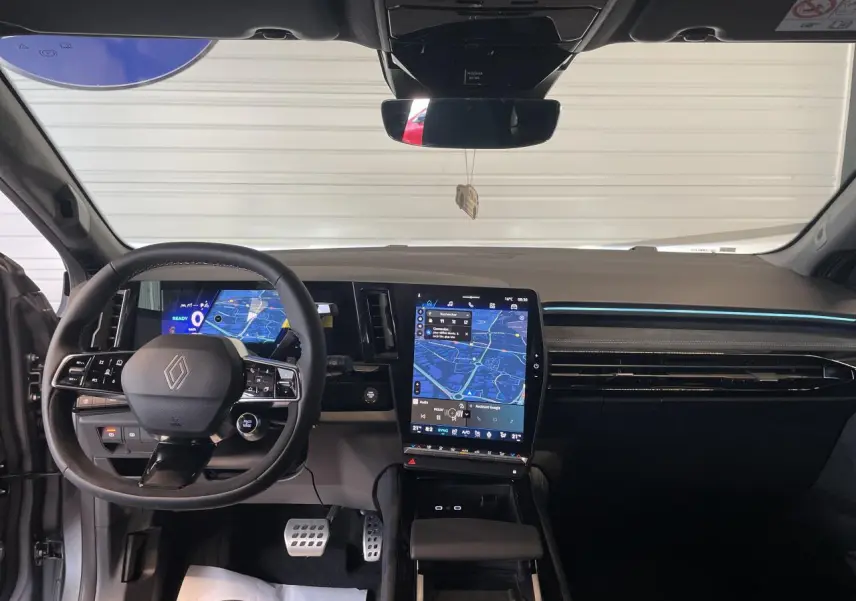 Vue intérieure avant du tableau de bord du Renault Austral gris satin mat avec écran tactile vertical et volant Alcantara.