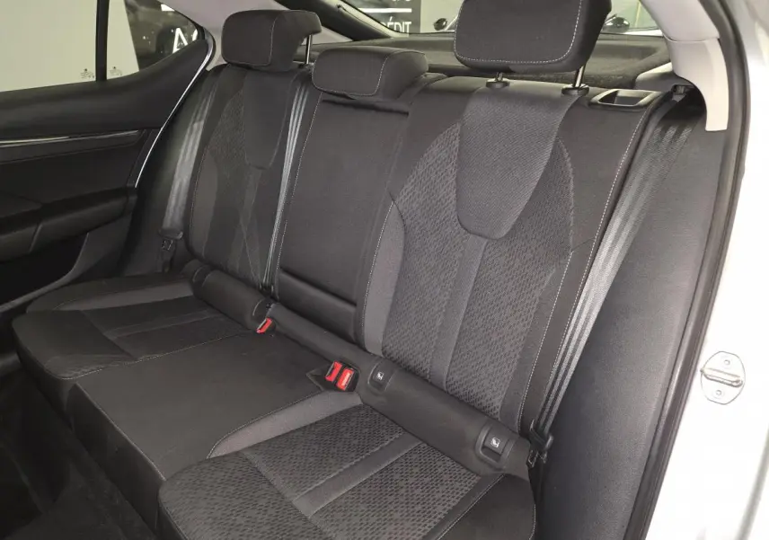 Vue intérieure sur la banquette arrière noire en tissu de la Skoda Octavia 2023, avec appuie-têtes et ceintures visibles.