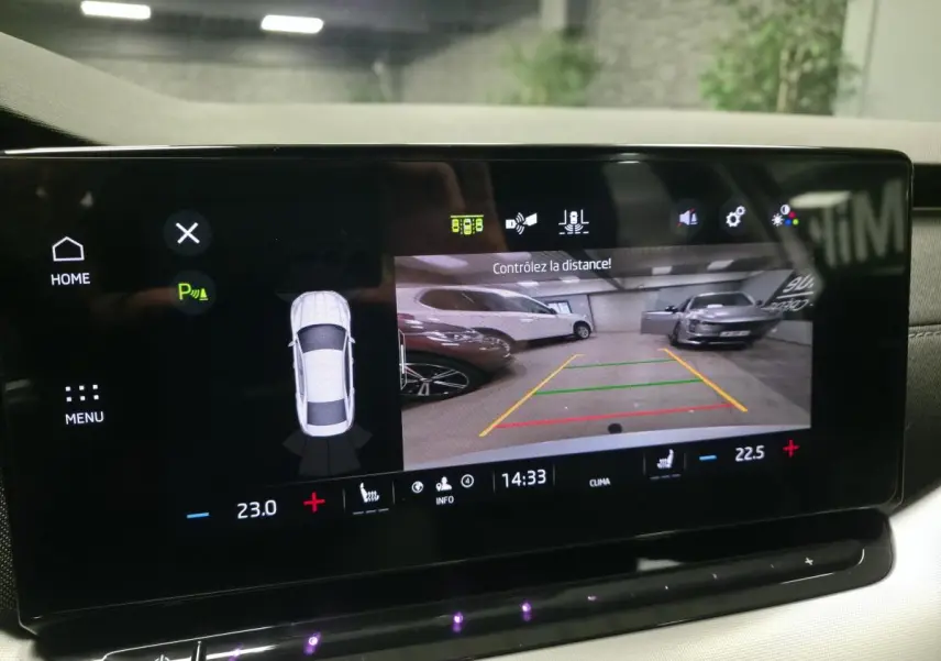 Écran central de la Skoda Octavia 2023 montrant la caméra de recul et l'aide au stationnement en intérieur.