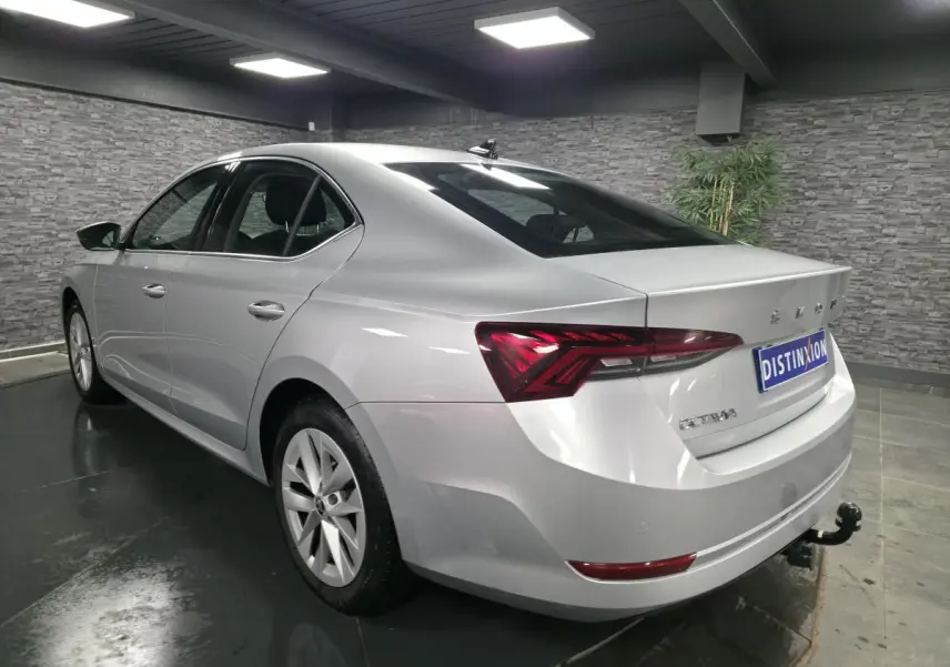 Vue 3/4 arrière droite d'une Skoda Octavia gris métallisé 2023 avec attelage fixe et jantes alliage 17 pouces.