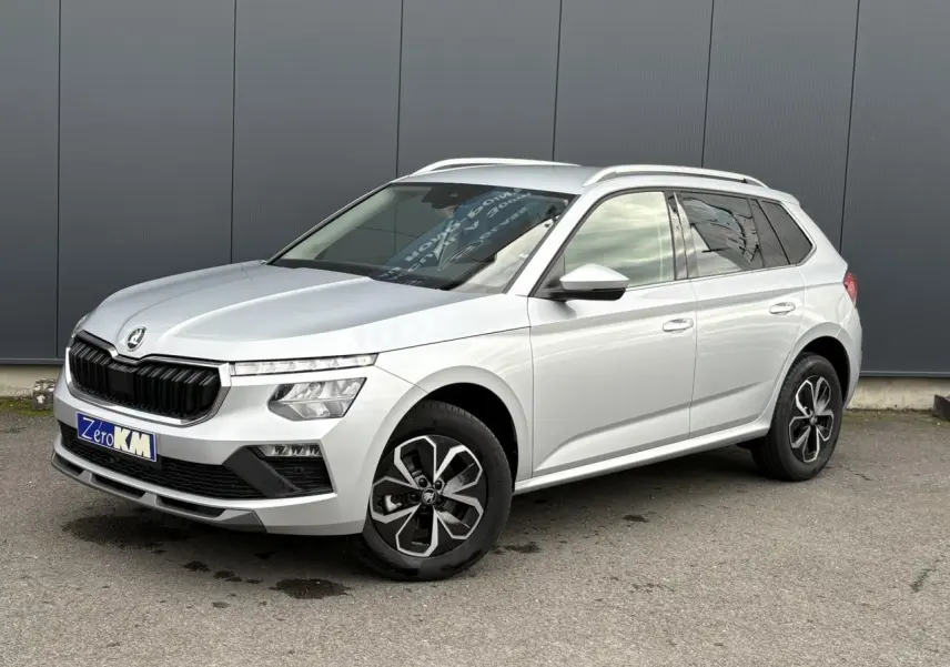 SKODA KAMIQ gris argent en vue 3/4 avant droit, avec vitres surteintées et jantes alliage 16 pouces.