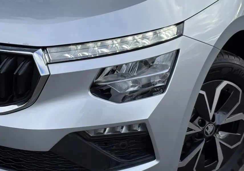 Gros plan sur l'avant droit gris argent du Skoda Kamiq 2025, mettant en valeur les phares LED et la jante alliage.