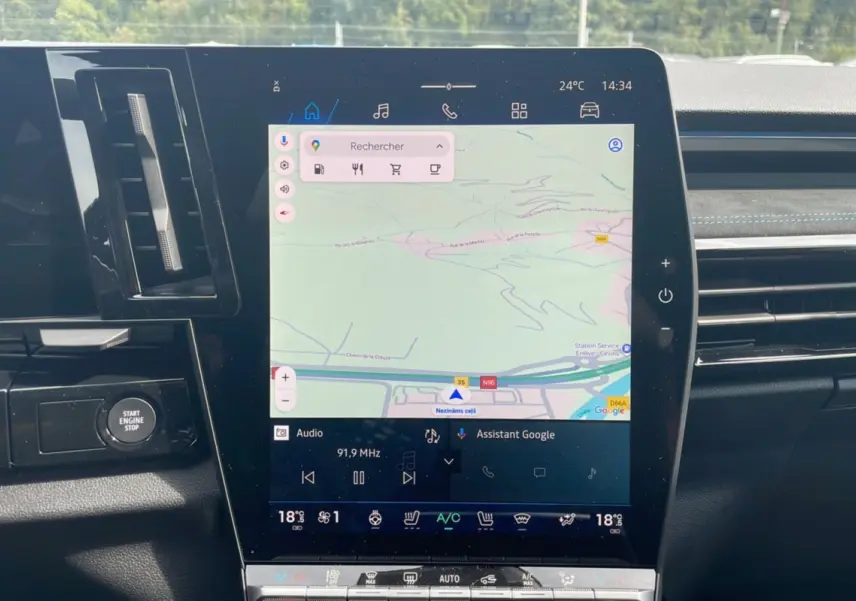 Vue intérieure centrée sur l'écran tactile du tableau de bord du Renault Austral gris schiste avec navigation et commandes climatisation.