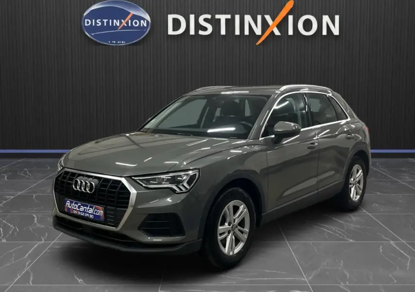 Audi Q3 Business gris vue 3/4 avant droit, avec calandre hexagonale et jantes alliage cinq branches.