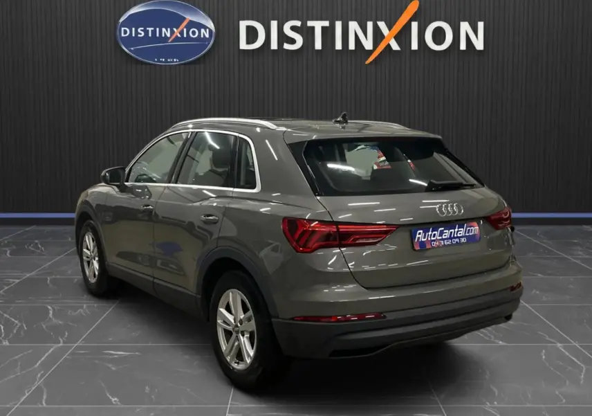 Audi Q3 Business gris vu en 3/4 arrière droit, avec feux arrière LED dynamiques et jantes alliage argentées.