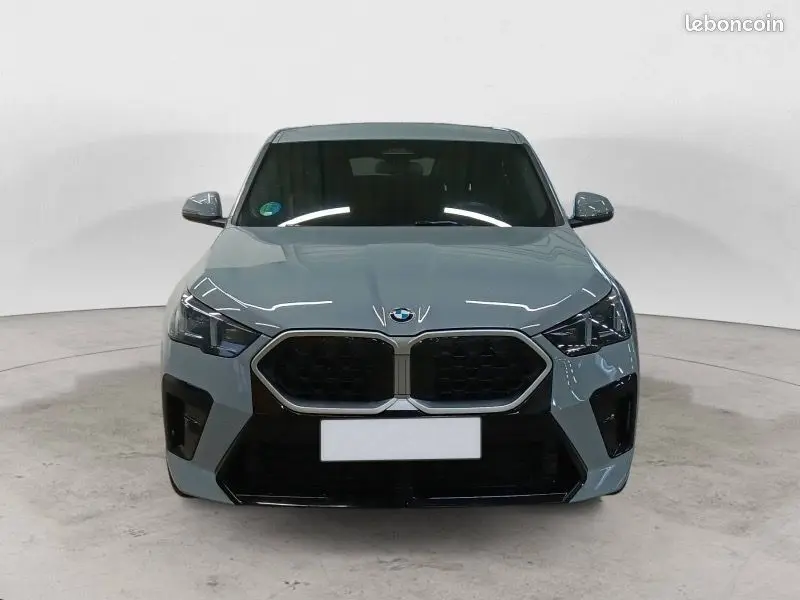 Vue 3/4 arrière droite d'une BMW X2 2.0DA 163 CH M Sport gris Skyscraper métallisé avec jantes noires et feux LED distinctifs.