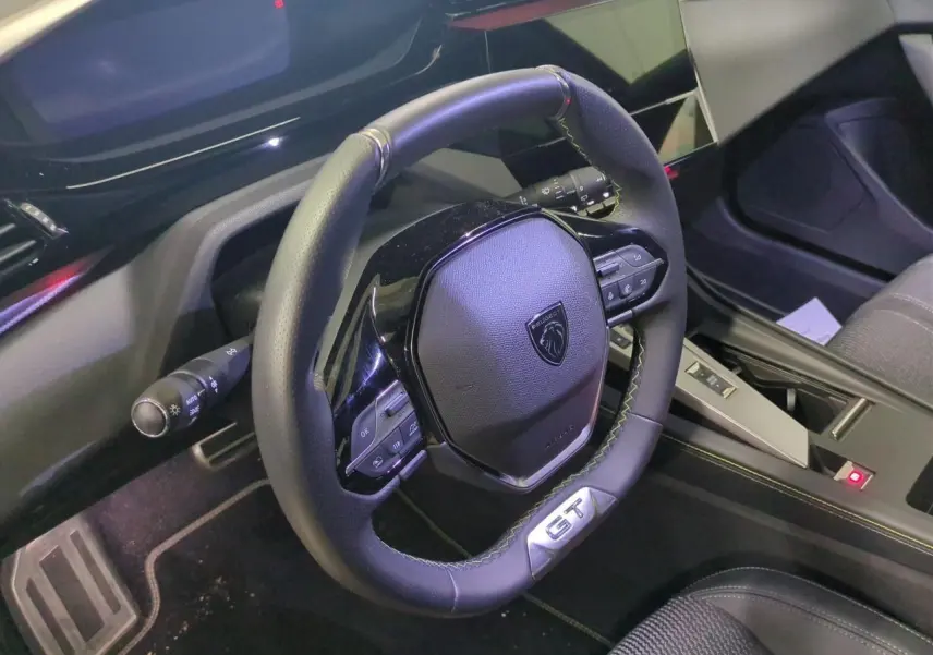 Vue intérieure centrée sur le volant cuir noir GT et la console centrale de la Peugeot 308 2025.