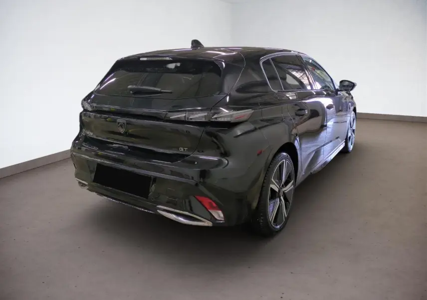 Vue 3/4 arrière droit d'une Peugeot 308 GT noire Perla avec jantes alliage 18 pouces et feux LED distinctifs.