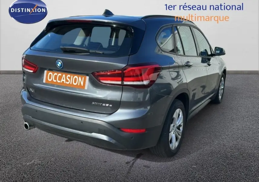 BMW X1 gris foncé vue 3/4 arrière droit, avec jantes alliage 18 pouces et feux arrière LED distinctifs.