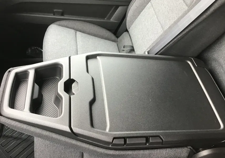 Vue rapprochée du plateau bureau mobile noir sur la banquette grise côté passager du Renault Master blanc 2025.