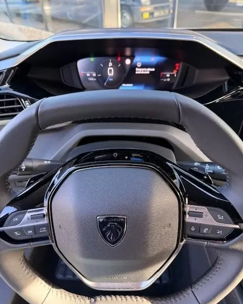 Vue intérieure centrée sur le volant cuir noir et le combiné d'instruments numérique de la Peugeot 308 Hybrid 145 e-DCS6 Allure.