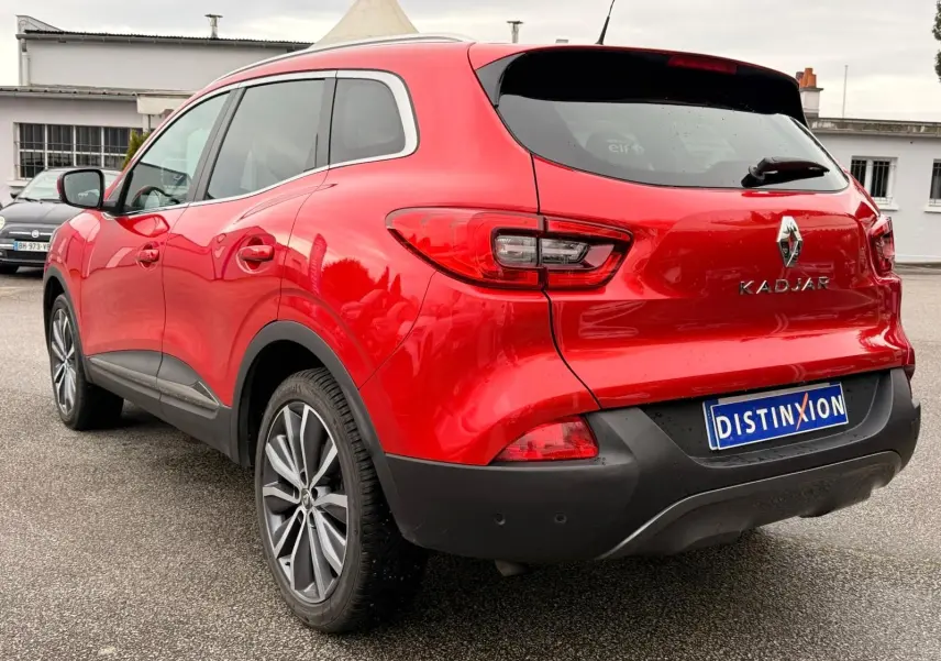 Renault Kadjar rouge flamme vu en 3/4 arrière droit, avec jantes alliage bi-ton et feux arrière LED distinctifs.