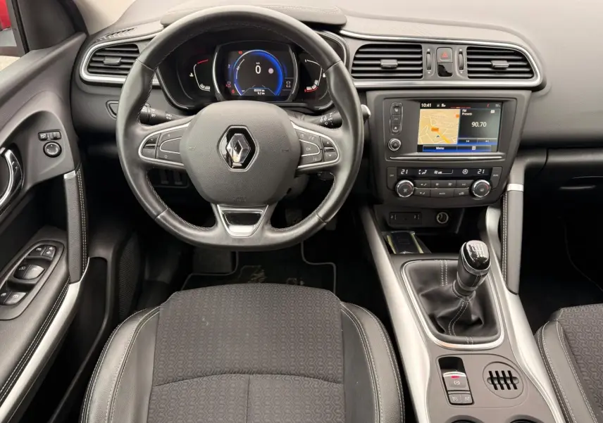 Vue intérieure centrée sur le volant et la console centrale du Renault Kadjar 1.2 TCE 130, sièges noirs et tableau de bord moderne.