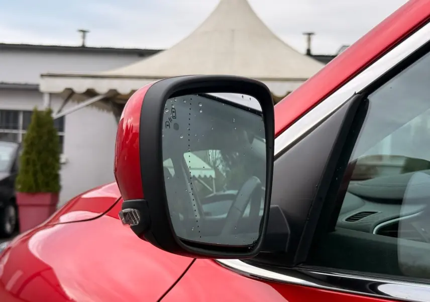 Rétroviseur côté gauche rouge flamme du Renault Kadjar 1.2 TCE 130 Energy INTENS avec gouttes d'eau visibles.