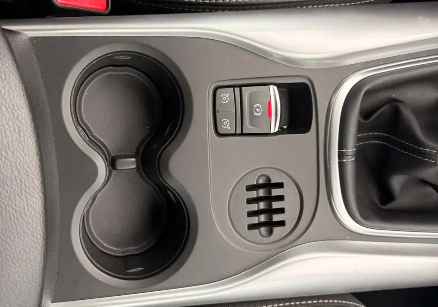 Vue plongeante sur la console centrale noire du Renault Kadjar 2016 avec porte-gobelets et frein à main électrique.