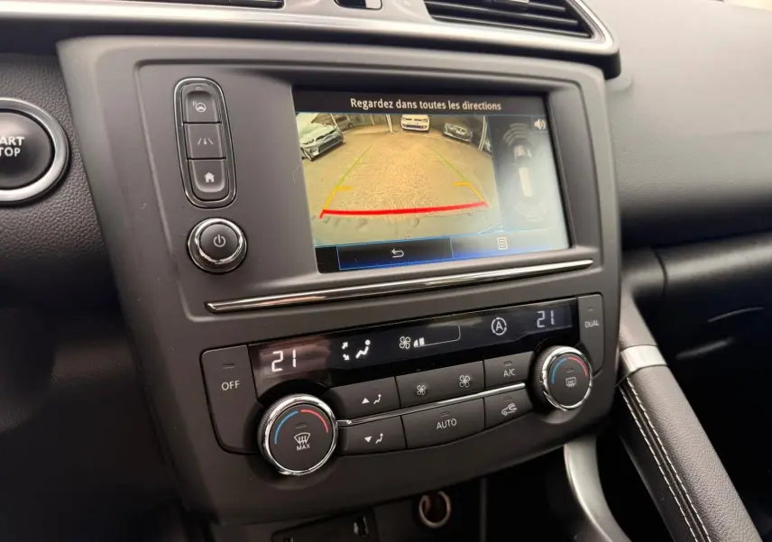 Vue rapprochée de la console centrale du Renault Kadjar 2016, écran de caméra de recul et commandes de climatisation visibles.