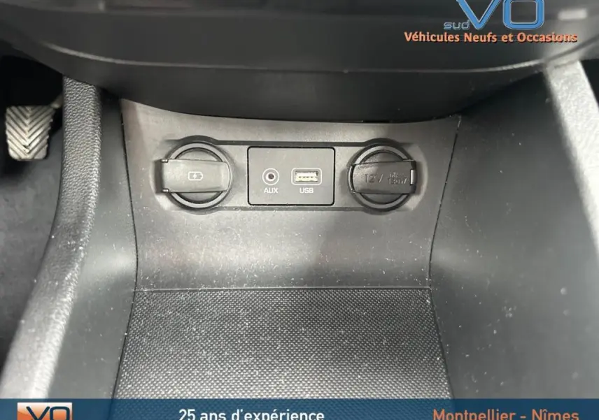 Prise USB, entrée auxiliaire et allume-cigare au centre console d'une Hyundai i20 blanche essence 2019.