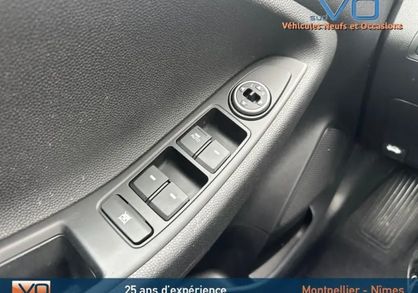 Gros plan sur les commandes des vitres électriques côté conducteur d'une Hyundai i20 blanche, version 2019.