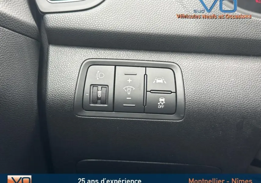 Gros plan sur les commandes de réglage d'éclairage et d'aide à la conduite dans l'habitacle d'une Hyundai i20 blanche 2019.