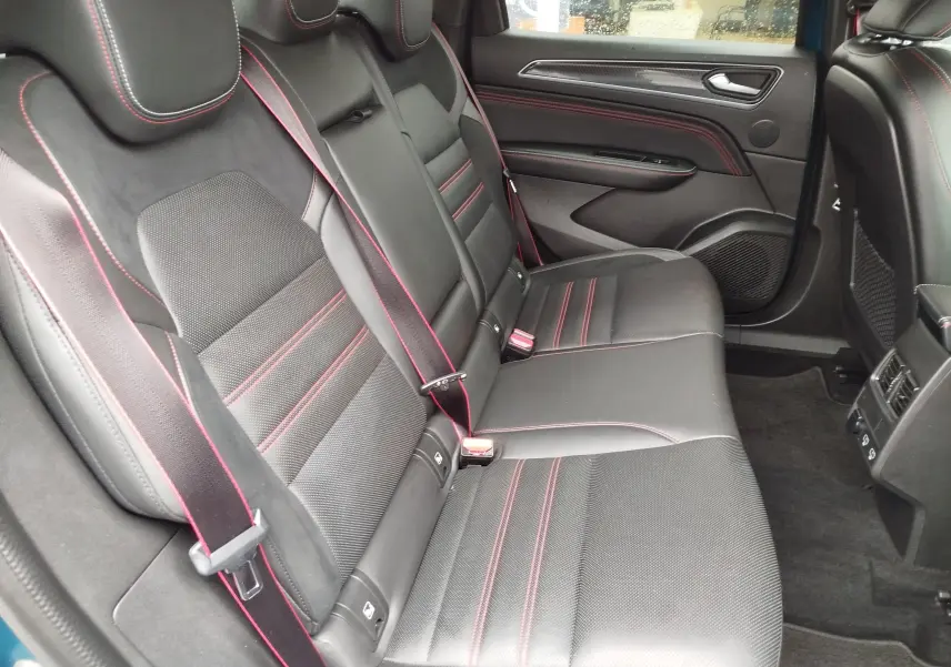 Vue intérieure arrière côté droit montrant les sièges noirs en cuir et alcantara avec surpiqûres rouges du Renault Arkana.
