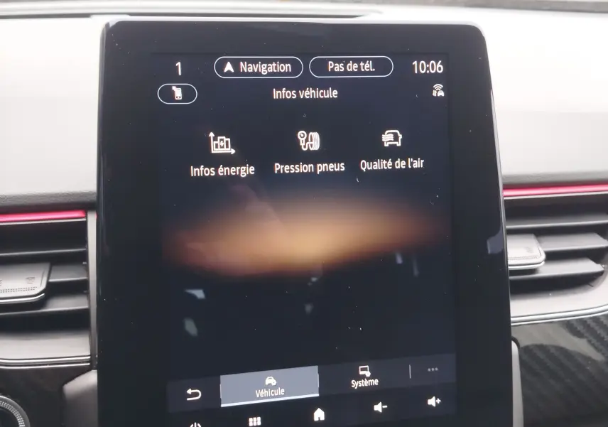 Écran tactile central du tableau de bord du Renault Arkana 2022 affichant les infos véhicule, entouré de garnitures noires et rouges.