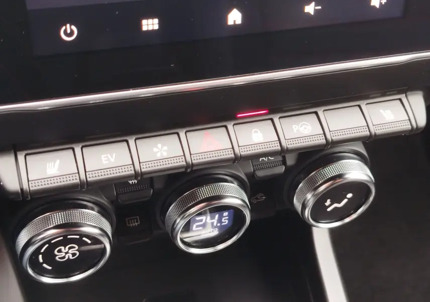 Gros plan sur la console centrale du Renault Arkana bleu Zanzibar 2022, montrant les commandes de climatisation et les boutons fonctionnels.