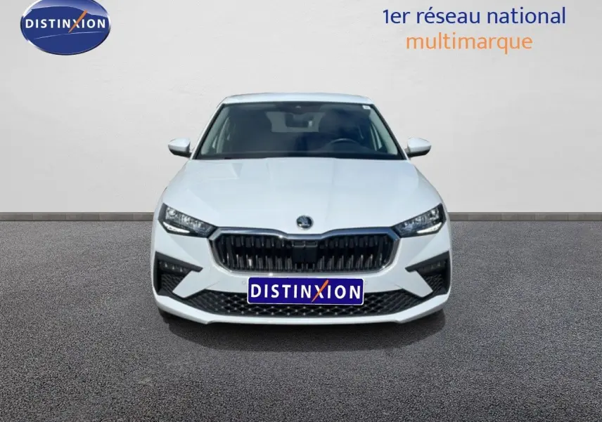 Vue frontale d'une Skoda Scala blanc glacier avec calandre noire et phares LED allumés sur fond neutre.